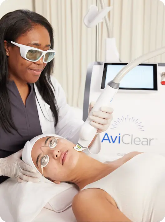 AviClear model beside the acne laser device; model, not an actual patient